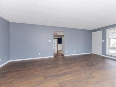 unfurnished living room featuring dark wood-type flooring