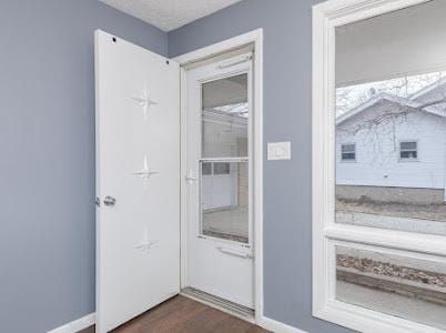 entryway with dark wood-type flooring and a textured ceiling