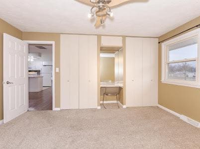 unfurnished bedroom featuring light colored carpet and ceiling fan