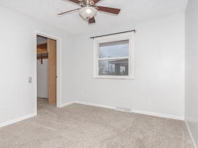 spare room featuring ceiling fan and light colored carpet