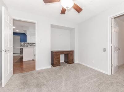 unfurnished bedroom featuring light colored carpet and ceiling fan