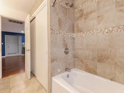 bathroom featuring tiled shower / bath combo and tile patterned floors