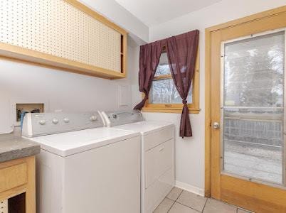 washroom featuring cabinets, light tile patterned floors, and independent washer and dryer