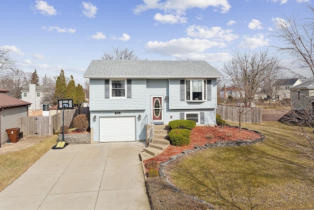 raised ranch featuring a garage and a front lawn