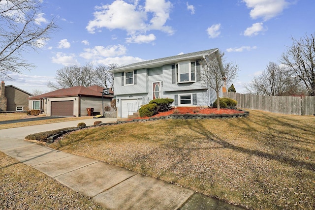 raised ranch with a garage and a front lawn