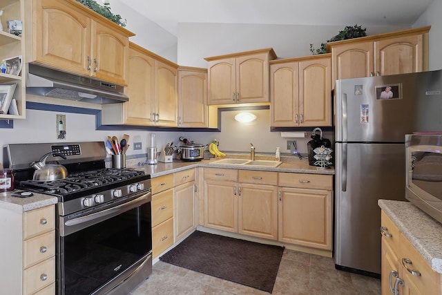 kitchen featuring stainless steel appliances, lofted ceiling, sink, and light brown cabinetry