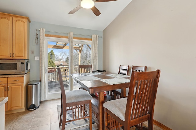 dining area with vaulted ceiling, ceiling fan, and light tile patterned flooring