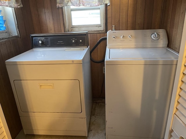 washroom with separate washer and dryer and wood walls