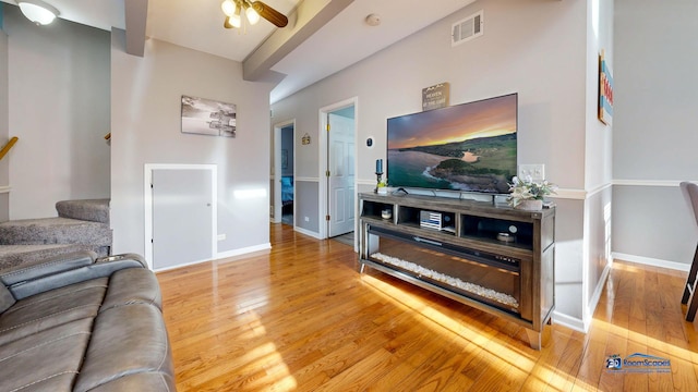 living room with stairway, baseboards, visible vents, and light wood-type flooring