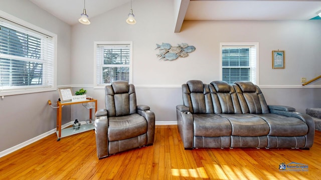 living room with stairs, vaulted ceiling, baseboards, and light wood finished floors