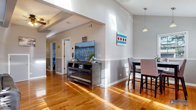 dining space featuring visible vents, baseboards, wood finished floors, and vaulted ceiling with beams