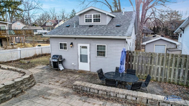 back of house with a patio area, a fenced backyard, and roof with shingles