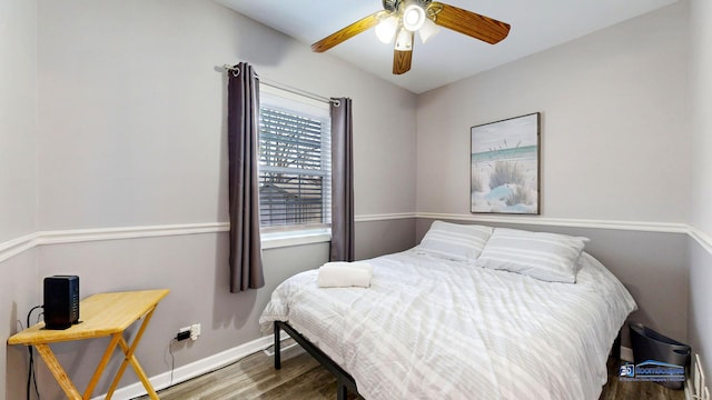 bedroom featuring ceiling fan, baseboards, and wood finished floors