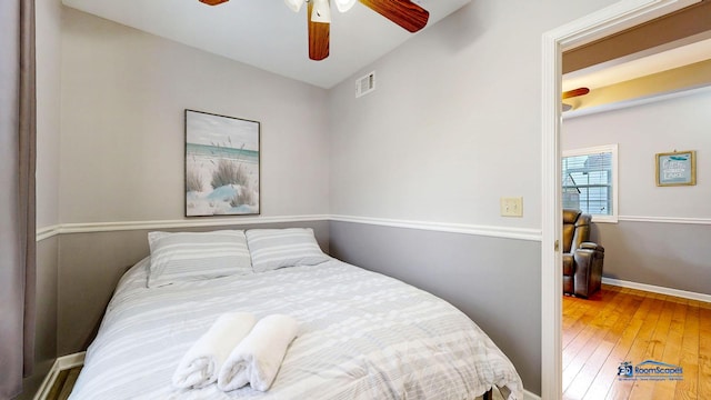 bedroom featuring visible vents, wood-type flooring, baseboards, and a ceiling fan