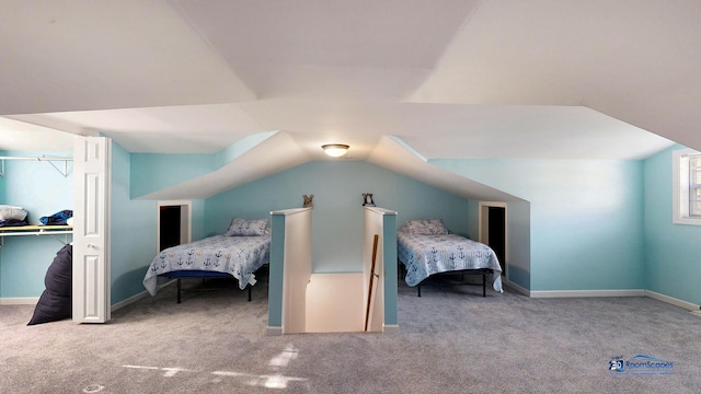 carpeted bedroom featuring baseboards, lofted ceiling, and a closet