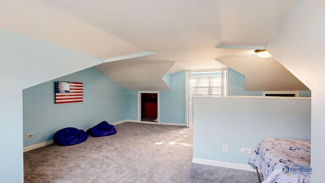 unfurnished bedroom featuring vaulted ceiling, carpet flooring, and baseboards