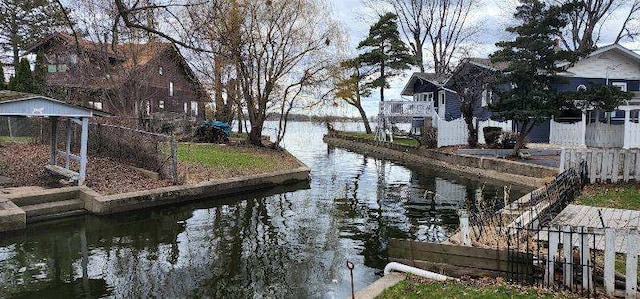 view of dock with fence and a water view