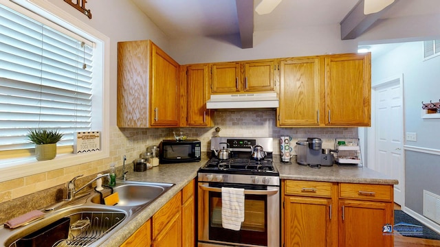 kitchen featuring a sink, black microwave, under cabinet range hood, stainless steel gas range oven, and backsplash