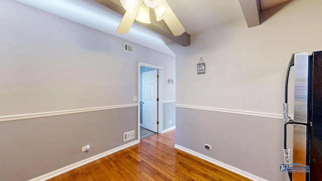 unfurnished room featuring visible vents, baseboards, ceiling fan, and hardwood / wood-style flooring