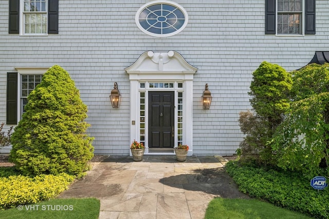 view of exterior entry with a patio