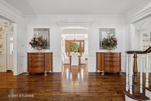 entryway featuring a notable chandelier, dark wood-type flooring, and ornamental molding