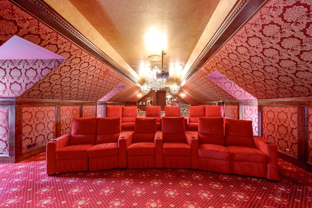 carpeted home theater room featuring a notable chandelier and vaulted ceiling