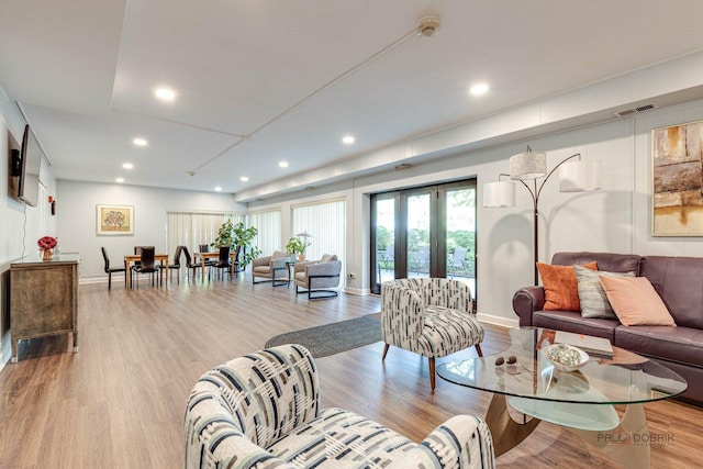 living room featuring french doors and light wood-type flooring