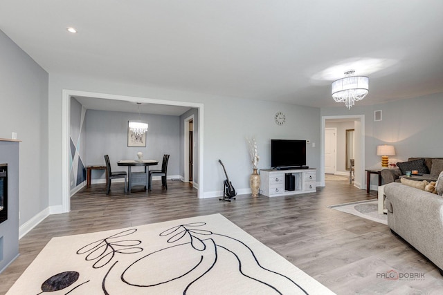 living room with an inviting chandelier and hardwood / wood-style flooring