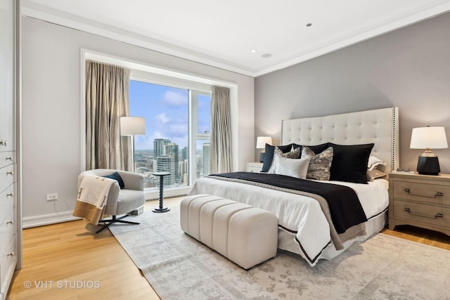 bedroom with light hardwood / wood-style flooring and ornamental molding