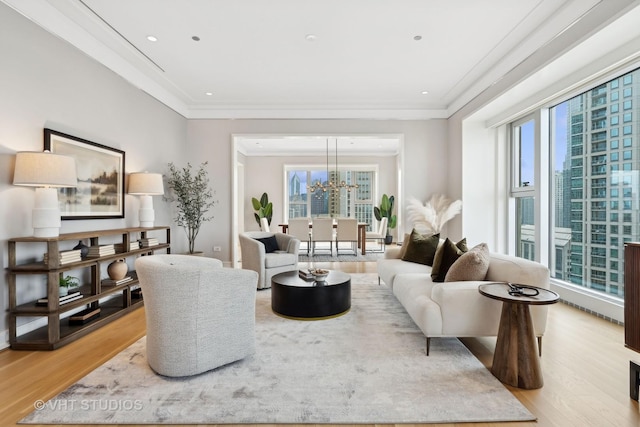 living room featuring ornamental molding, a healthy amount of sunlight, and light hardwood / wood-style floors