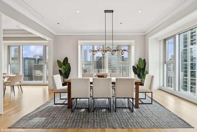 dining space with crown molding, wood-type flooring, and a chandelier