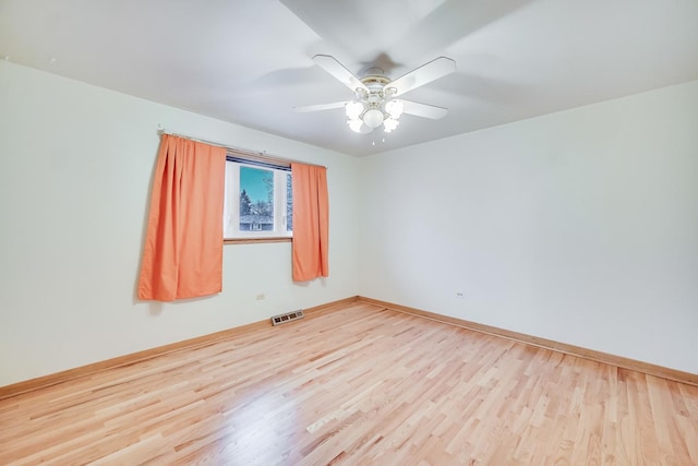 empty room with ceiling fan and light hardwood / wood-style flooring