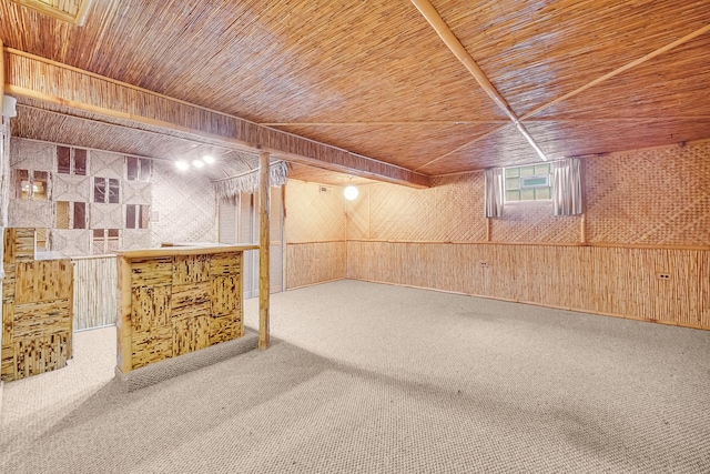 basement with wood walls, bar area, carpet, and wooden ceiling