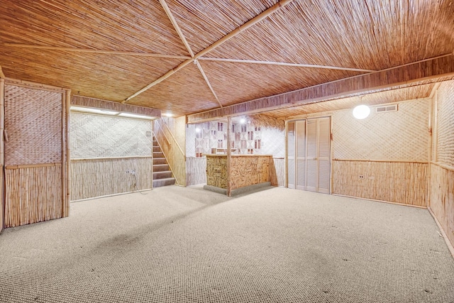 basement featuring wood ceiling, indoor bar, wooden walls, and carpet