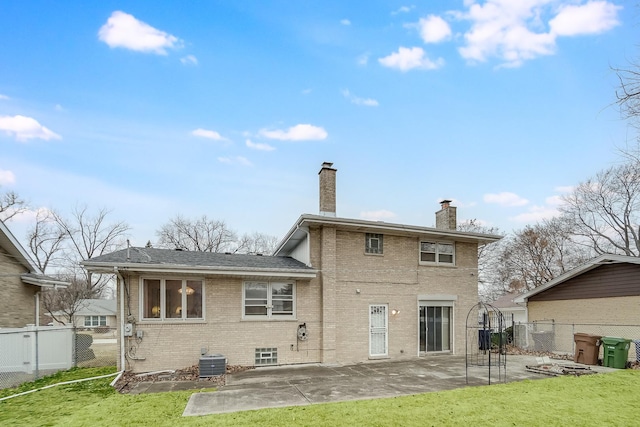 back of property with central AC, a patio area, and a lawn