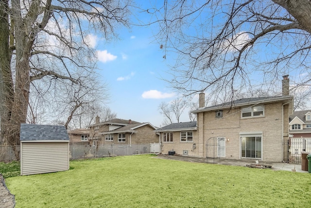 back of property featuring a storage shed, a lawn, and a patio area