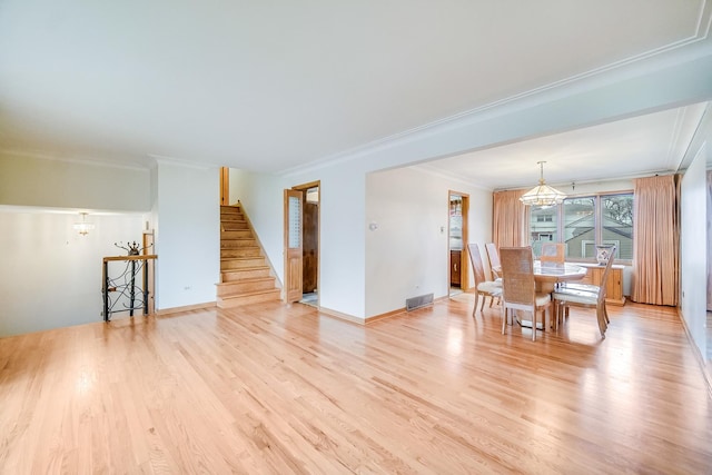 living room with ornamental molding, light hardwood / wood-style floors, and a chandelier