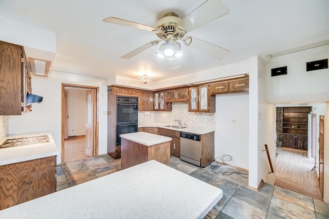 kitchen featuring sink, ceiling fan, stainless steel appliances, tasteful backsplash, and a kitchen island