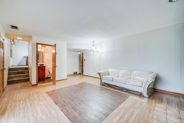 living room featuring a notable chandelier and light wood-type flooring