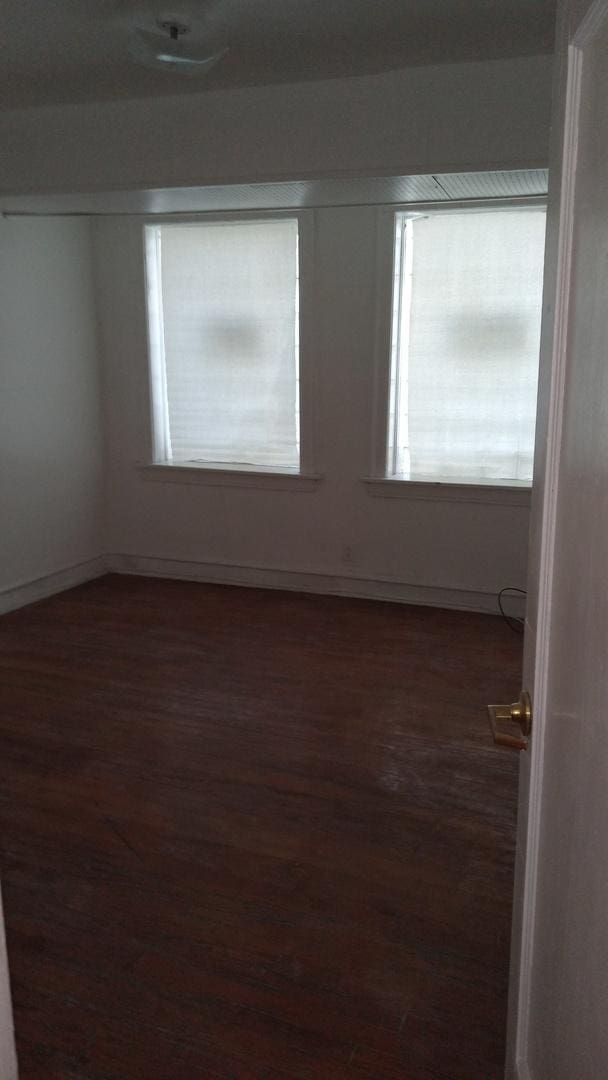 empty room with dark hardwood / wood-style flooring