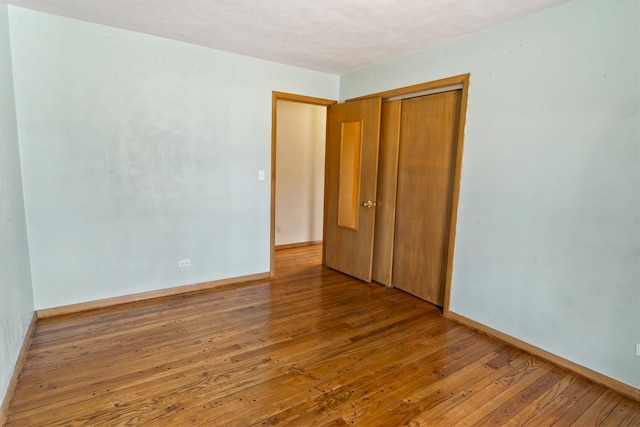 unfurnished bedroom with hardwood / wood-style flooring and a closet