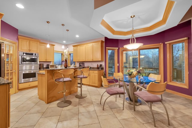 kitchen featuring hanging light fixtures, a center island, stone countertops, and light brown cabinets