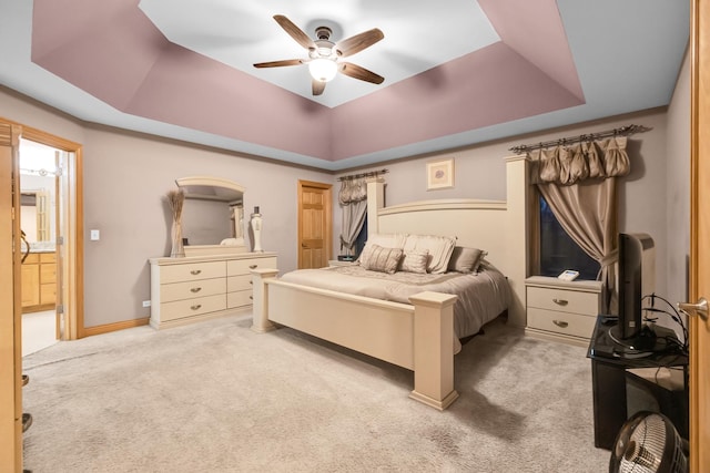 carpeted bedroom featuring a tray ceiling and ceiling fan