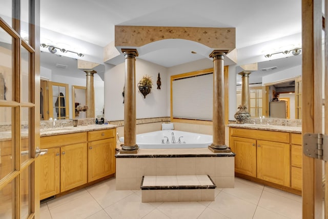 bathroom featuring tile patterned floors, vanity, tiled bath, and ornate columns