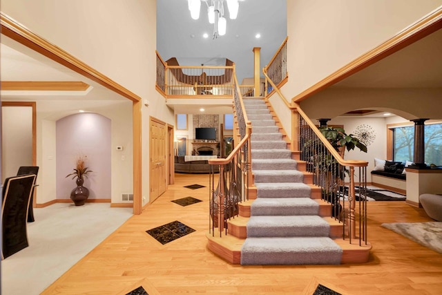 staircase featuring wood-type flooring and a towering ceiling