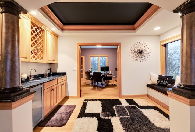 interior space featuring ornamental molding, dishwasher, sink, and a tray ceiling