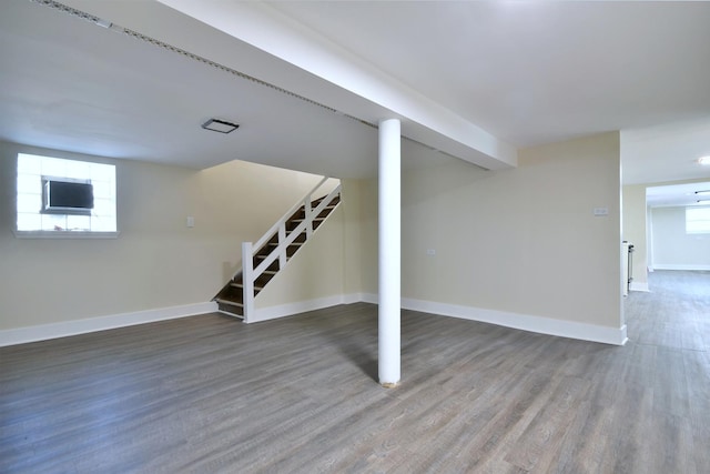 below grade area featuring stairs, wood finished floors, a wealth of natural light, and baseboards