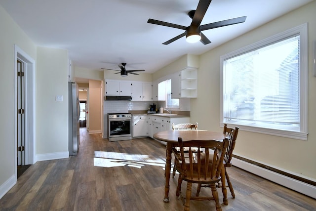 dining room with dark wood-style floors, a baseboard radiator, ceiling fan, and baseboards