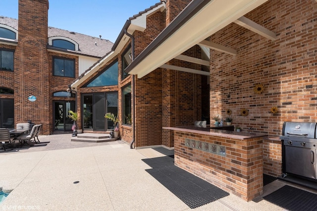 view of patio with an outdoor bar and grilling area