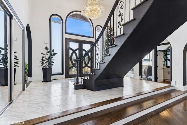 foyer featuring a towering ceiling and a chandelier